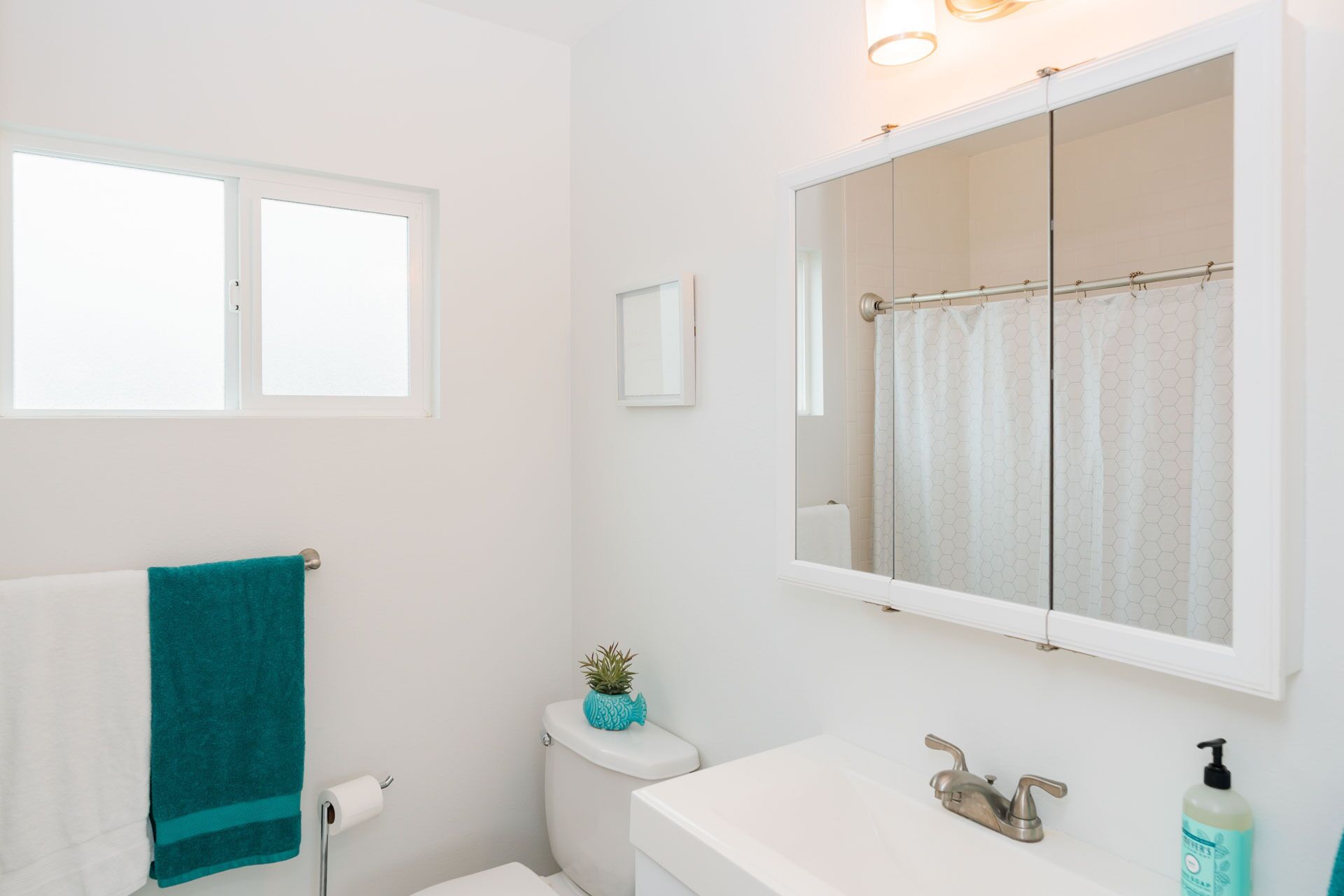 Une salle de bain avec des toilettes, un lavabo et un miroir.