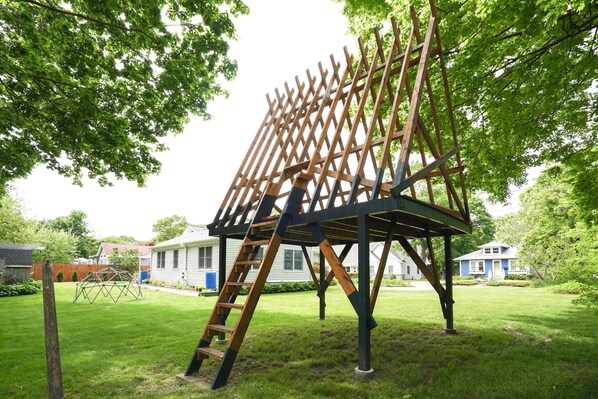 A wooden structure with a ladder, set in a grassy yard with houses in the background. - Barrington Beach 5 min Walk・Work・Relax・Play (Barrington)
