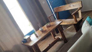 A wooden bench with a small table in front of a blue door. - 1 Bed - Sleeps 2 - Balcony - Sea View - Parking (Kalymnos)