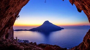 A cave entrance with a view of a calm sea and a mountain silhouette at sunset. - 1 Bed - Sleeps 2 - Balcony - Sea View - Parking (Kalymnos)