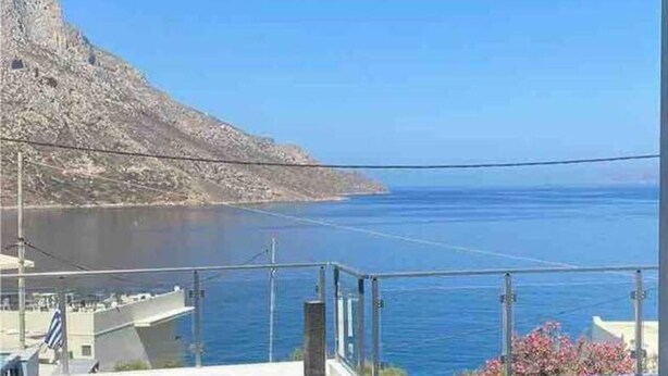 A coastal view with a clear sky, a calm sea, and a rocky hillside. - 1 Bed - Sleeps 2 - Balcony - Sea View - Parking (Kalymnos)