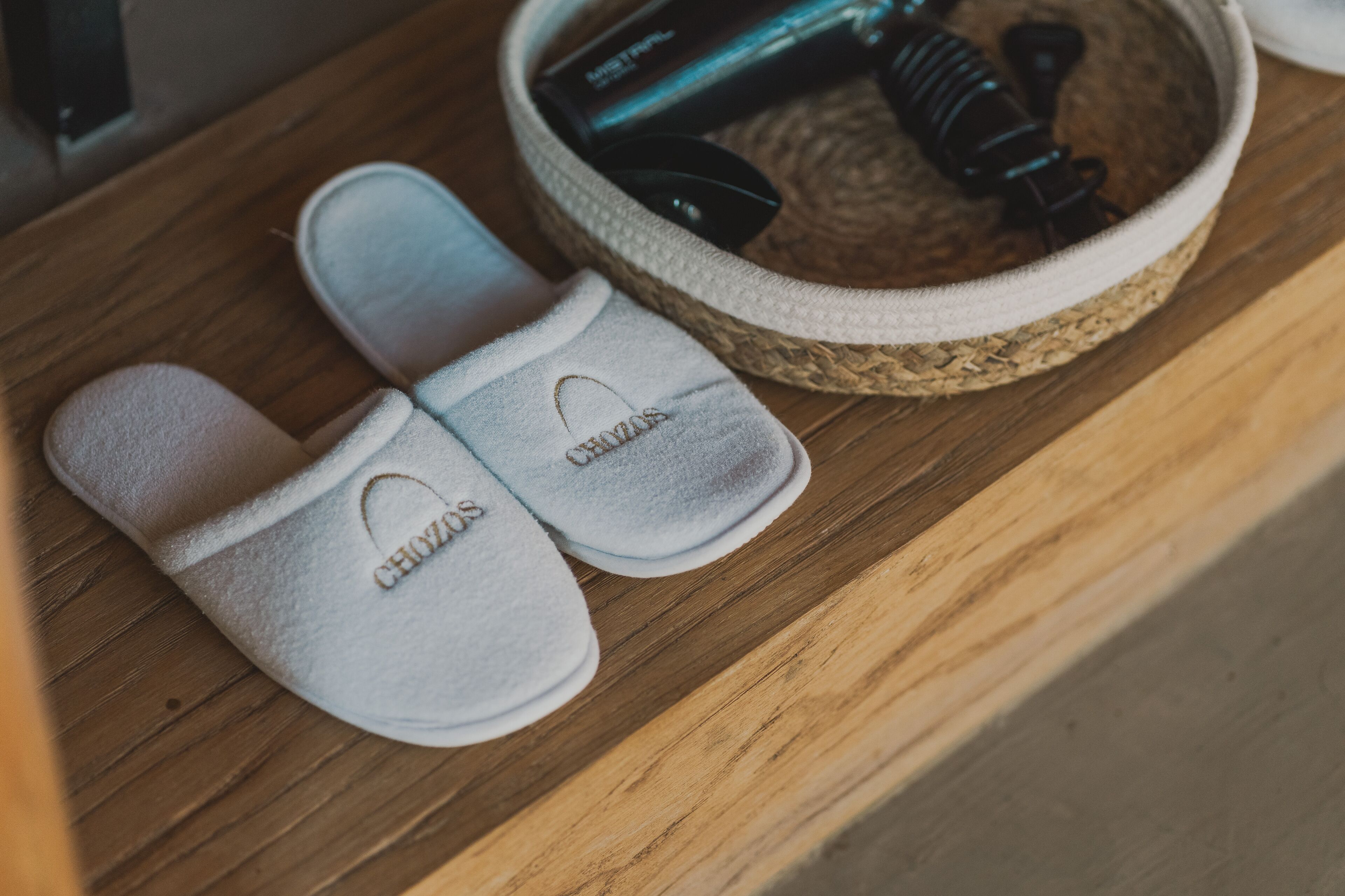 A pair of slippers with the brand name 'CHIZOS' on a wooden surface.