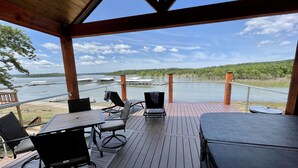 Eine überdachte Terrasse mit Blick auf einen See und eine Anlegestelle.