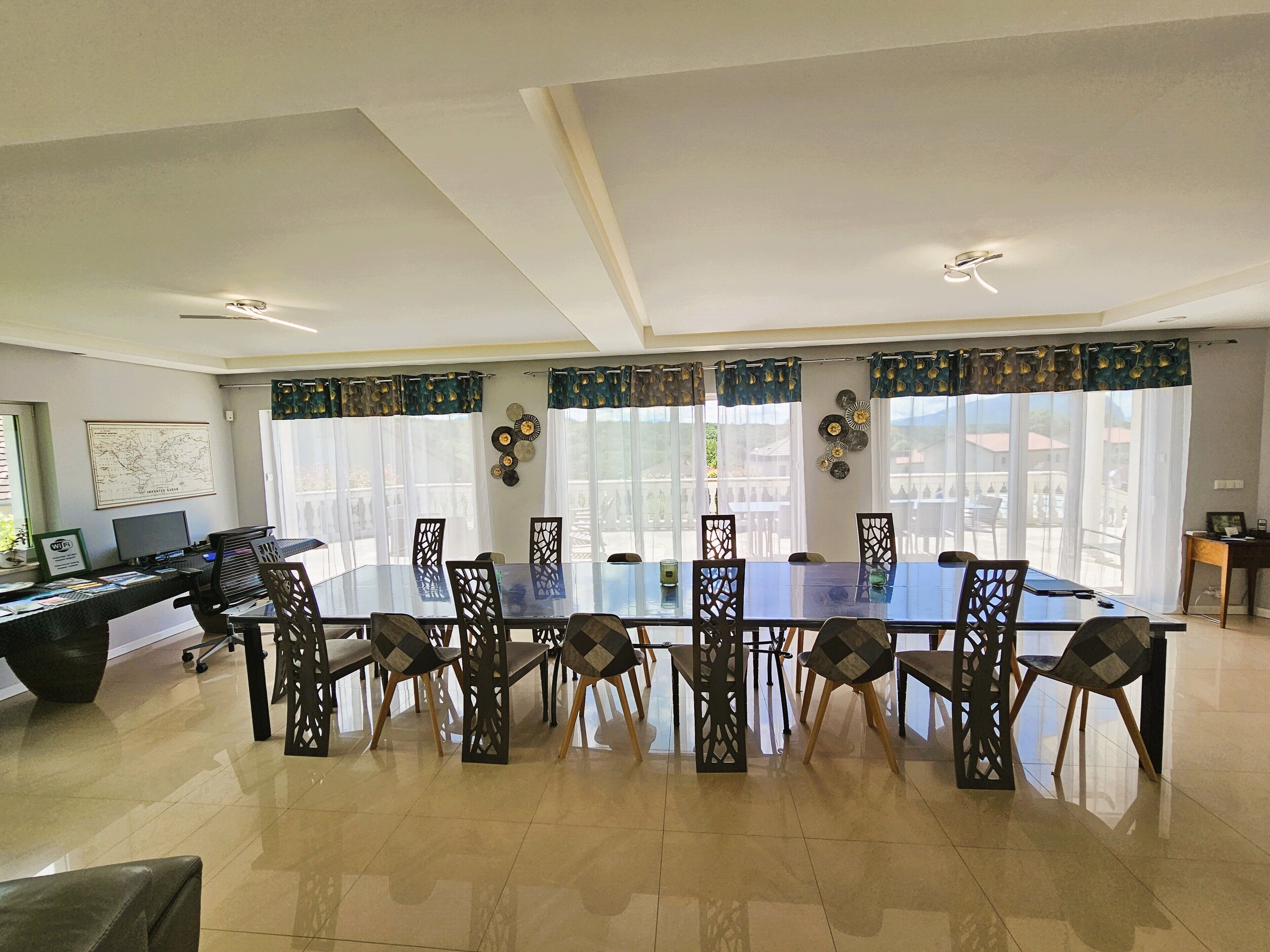 Un coin repas avec une table en verre, des chaises et une vue dégagée grâce à de grandes fenêtres.