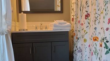 Een bad/douchecombinatie, een haardroger, handdoeken, zeep