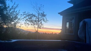 A room with a view of a sunset over a body of water, a tree, and a building with a window. - Lovely 1-Bdrm Apt w/ Hot Tub - 5 mins from Canyons (Cottonwood Heights)