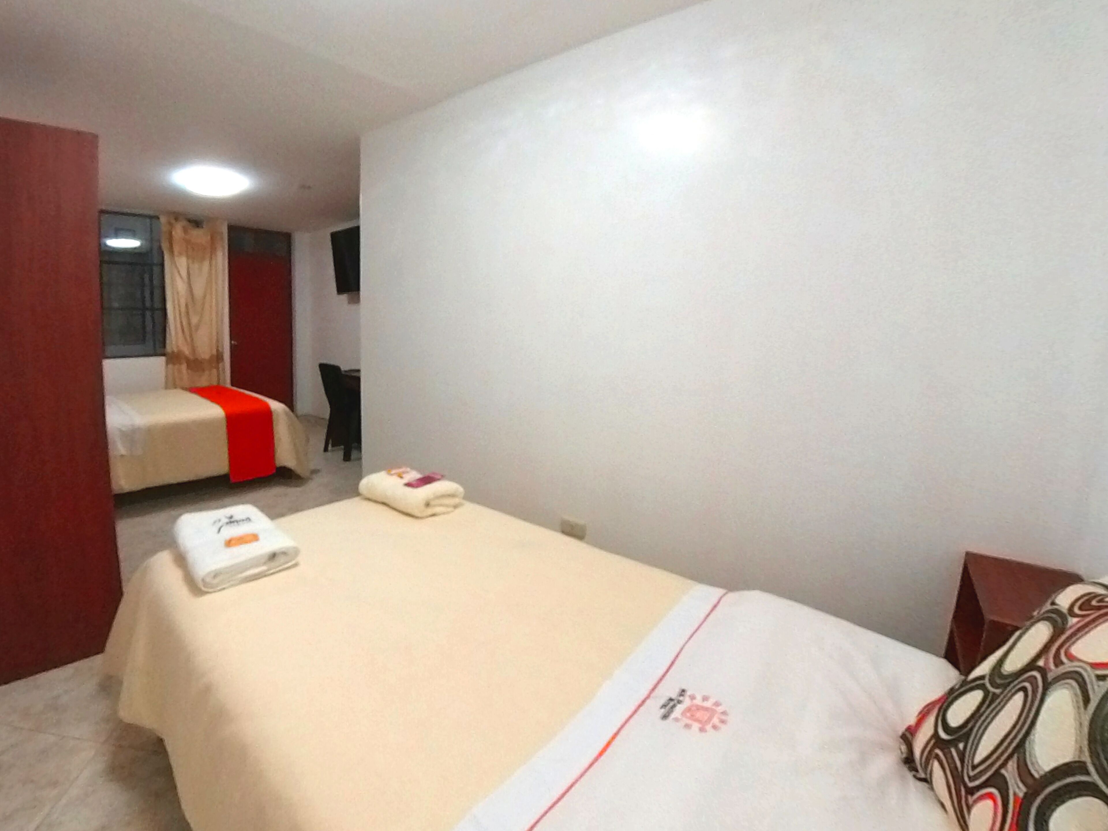 A hotel room with a bed, a chair, and a desk.