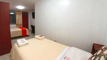 A hotel room with a bed, a chair, and a desk.