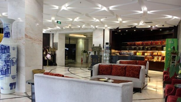 A modern lobby with seating areas, a reception desk, and a display of products. - Qing Shui Wan Business Club (Rongcheng)