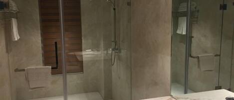 A modern bathroom with a glass-enclosed shower, a marble countertop, and a sink.