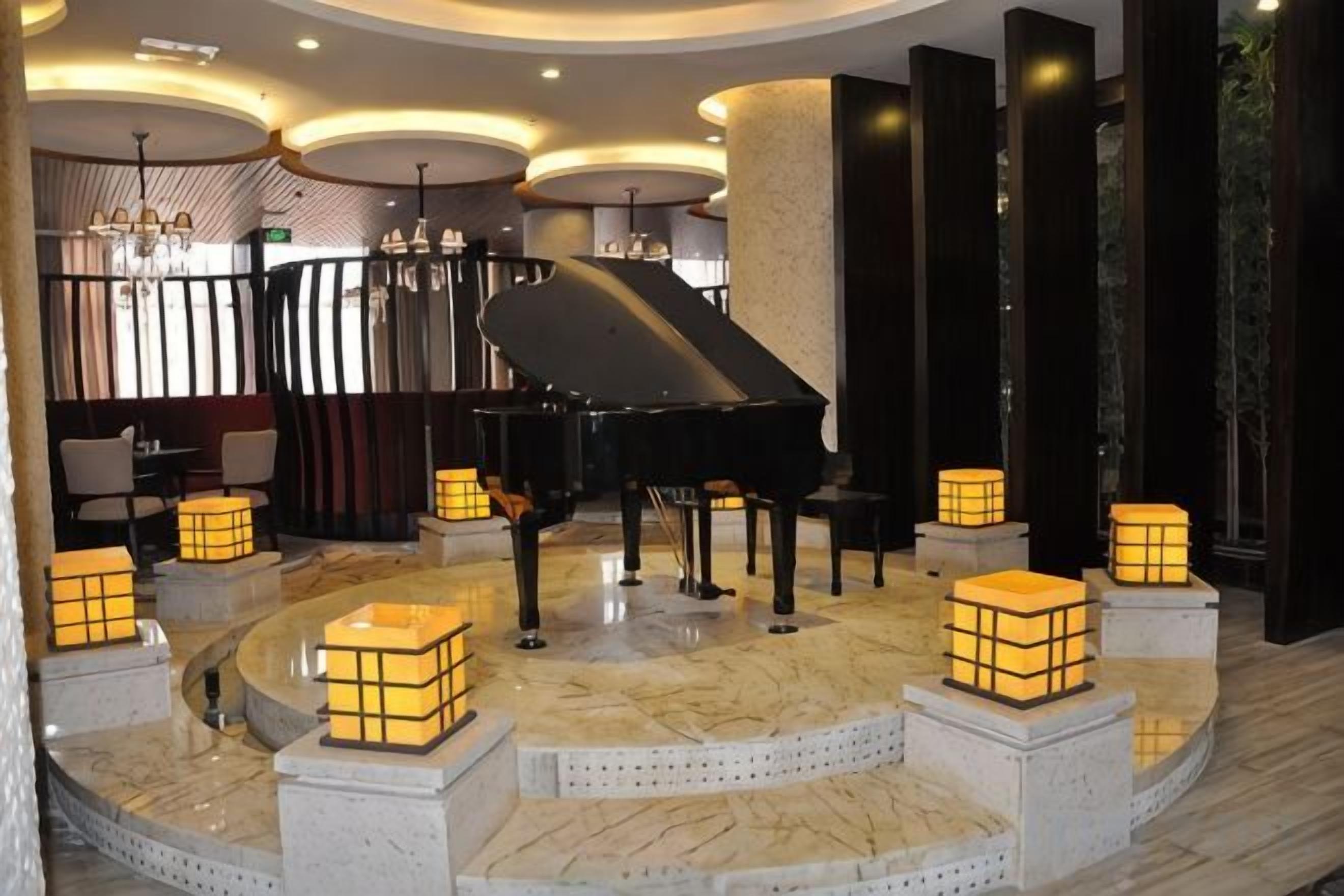 A grand piano in a lobby with a marble floor, surrounded by illuminated cube-shaped lights.