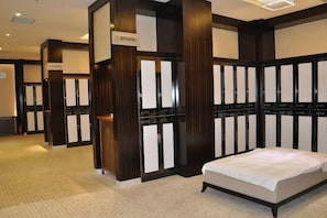 Habitación de hotel con una cama, un minibar y un espejo grande.