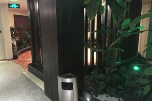 Eine Hotelhalle mit einer Rezeption, einer Pflanze und einem gemusterten Teppich.