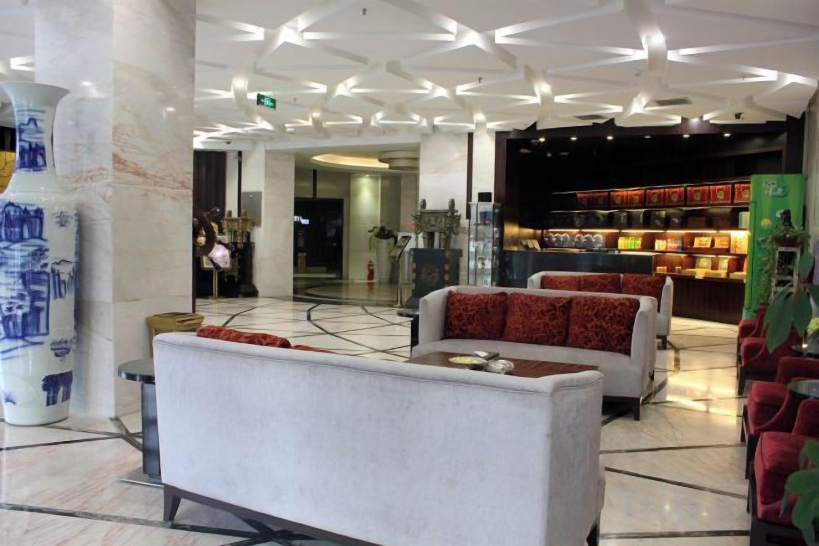 Un hall d’entrée avec des espaces aménagés pour s’asseoir, un grand vase et une présentation d’objets.