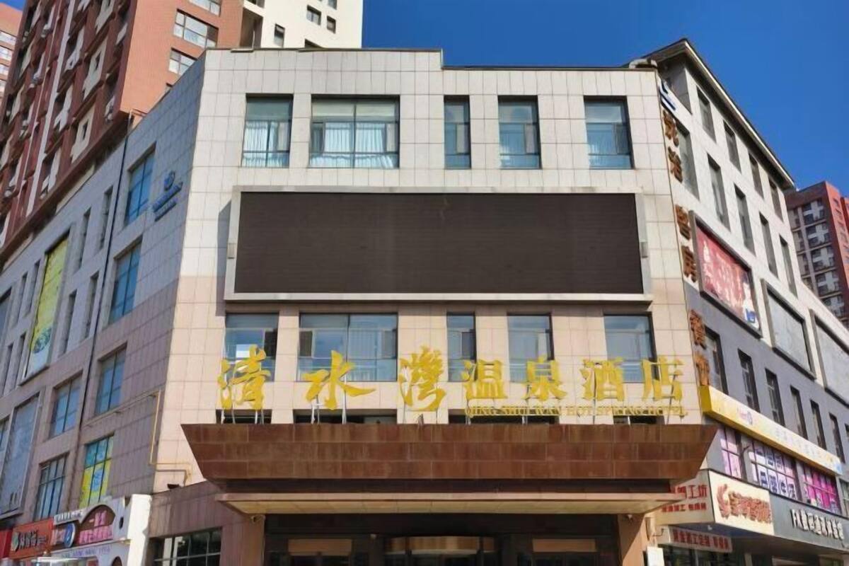 Ein Hotel mit moderner Fassade, das ein markantes Schild mit chinesischen Schriftzeichen zeigt.