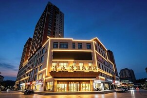 Un hotel de varios pisos con una entrada destacada y señalización.