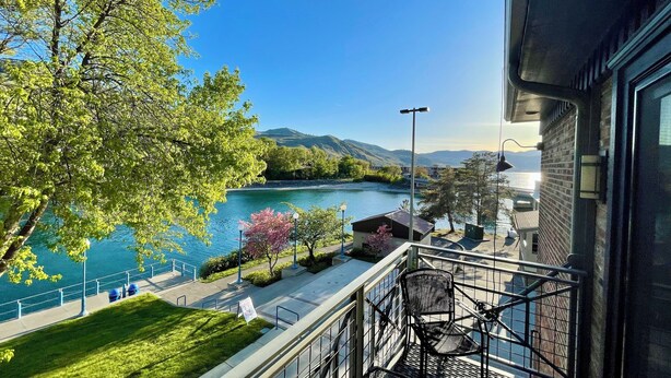 Ein Balkon mit Blick auf einen Fluss, Bäume und ferne Berge.