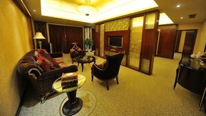 A hotel lobby with a sofa, armchair, coffee table, and a TV. - Zizhou International Hotel (Santai)