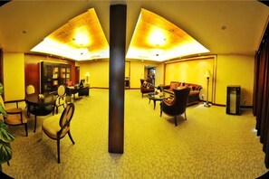 A hotel lobby with a central column, seating areas, and a reception desk. - Zizhou International Hotel (Santai)