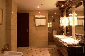 A bathroom with two sinks, a bathtub, and a large mirror. - Zizhou International Hotel (Santai)