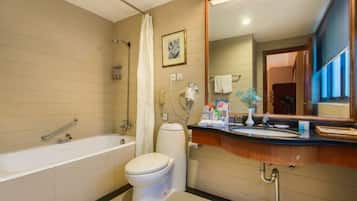 A modern bathroom with a bathtub, toilet, and vanity.