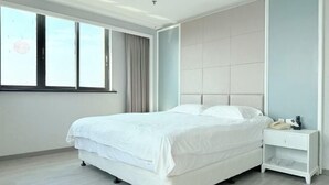 Une chambre moderne avec un grand lit, une table de chevet et une fenêtre avec des rideaux.
