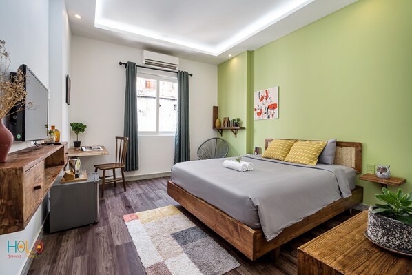 Relax in a serene space with a large bed, desk, and potted plant.