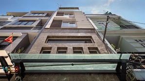 Um edifício de vários andares com design arquitetônico moderno, com grandes janelas e telhado plano.