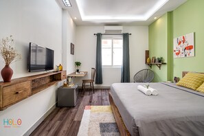 Relax in this serene bedroom with a large bed, flat-screen TV, and desk area.