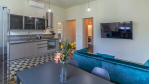 Una cocina moderna con comedor, sofá y televisor.