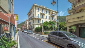 Calle con un edificio de varios pisos, balcones y cielo despejado.