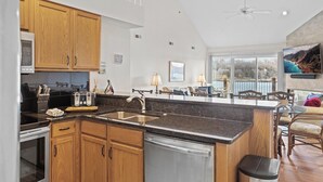 A modern kitchen with wooden cabinets, a stainless steel sink, and a dishwasher.