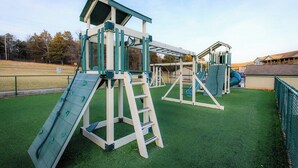 A playground with climbing structures, slides, and a covered area.