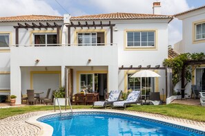 A two-story house with a swimming pool, outdoor seating, and a pergola. - CoolHouses Algarve Luz | Casa Sirrah (Luz)