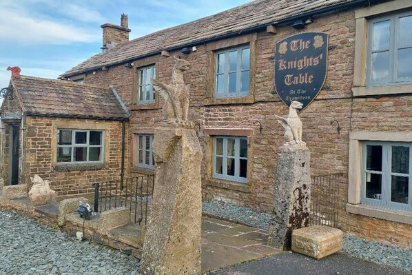 A traditional stone building with a sign reading "The Knights' Table."