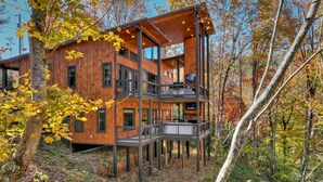 A multi-level wooden cabin with balconies, surrounded by trees and forest. - Modern 4BR Cabin w easy access, hot tub & a view! (Blue Ridge)