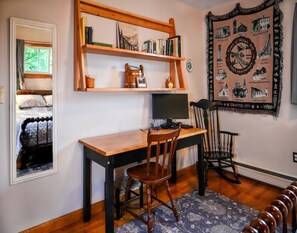 Work in comfort with a desk and chair, computer monitor, and large tapestry.