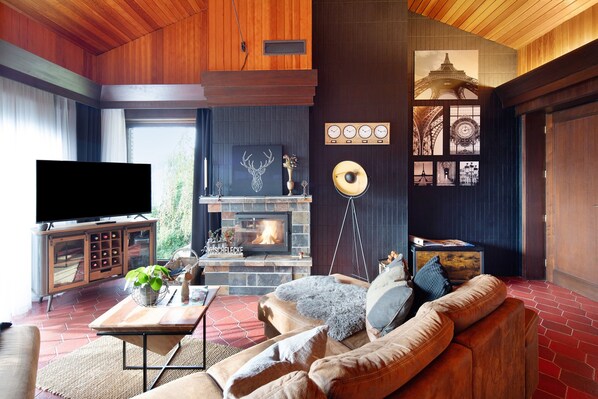 Una sala de estar acogedora con chimenea, televisión y un sofá.