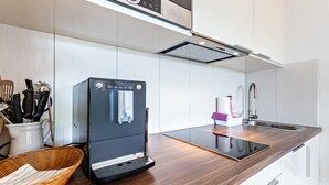 Une cuisine moderne équipée d’un lave-vaisselle encastré, d’un évier et d’un plan de travail doté d’une tablette.