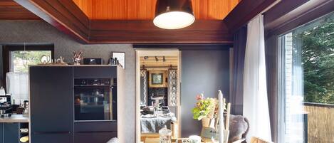 Un comedor con una mesa dispuesta para dos personas, techo de madera y vistas al exterior.