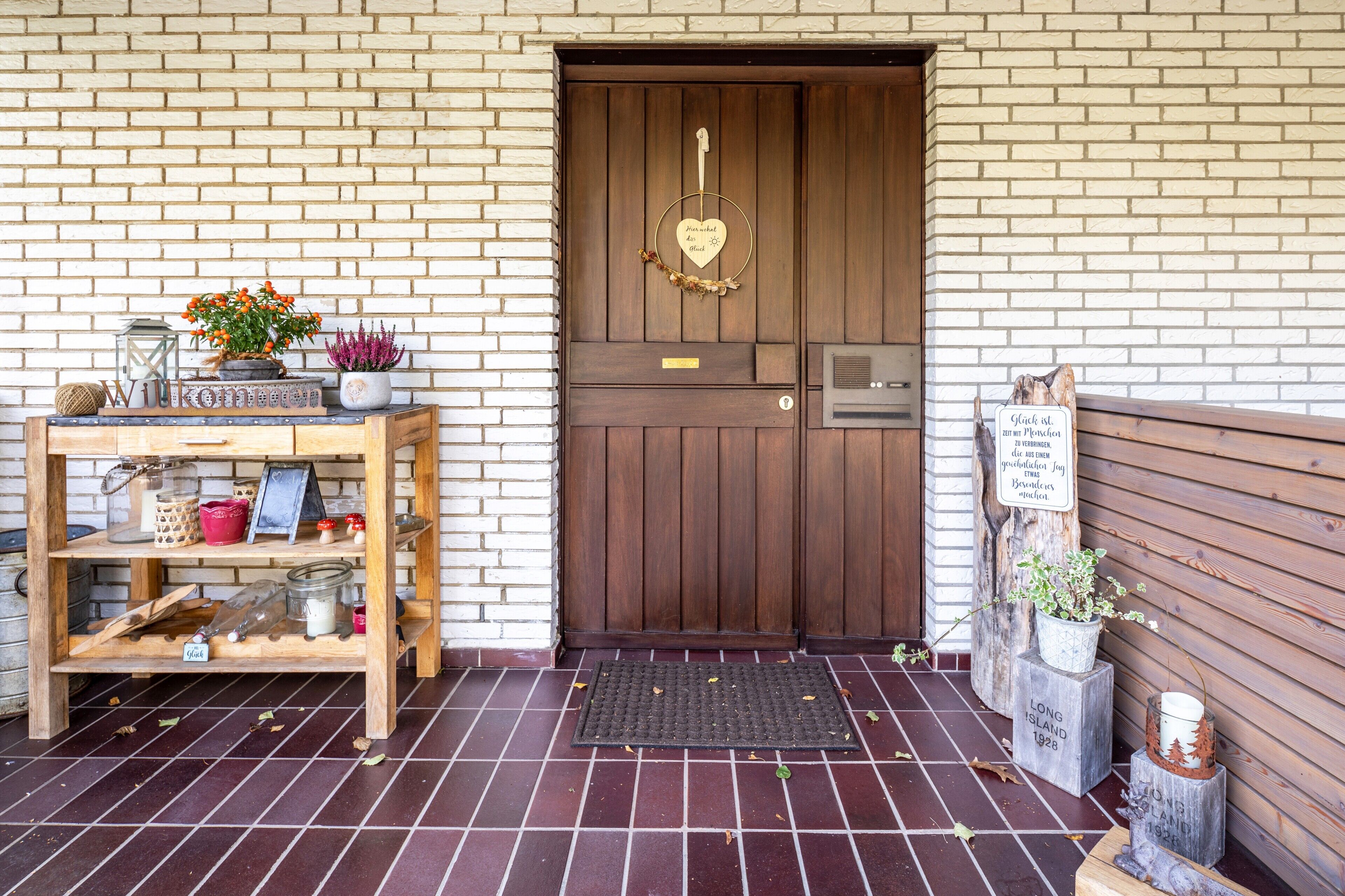 A wooden door with a heart-shaped keyhole, a wooden bench, and a small table with various items.