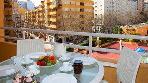Ein Balkon mit Frühstückstisch, mit Blick auf ein Wohngebiet mit mehrstöckigen Gebäuden.