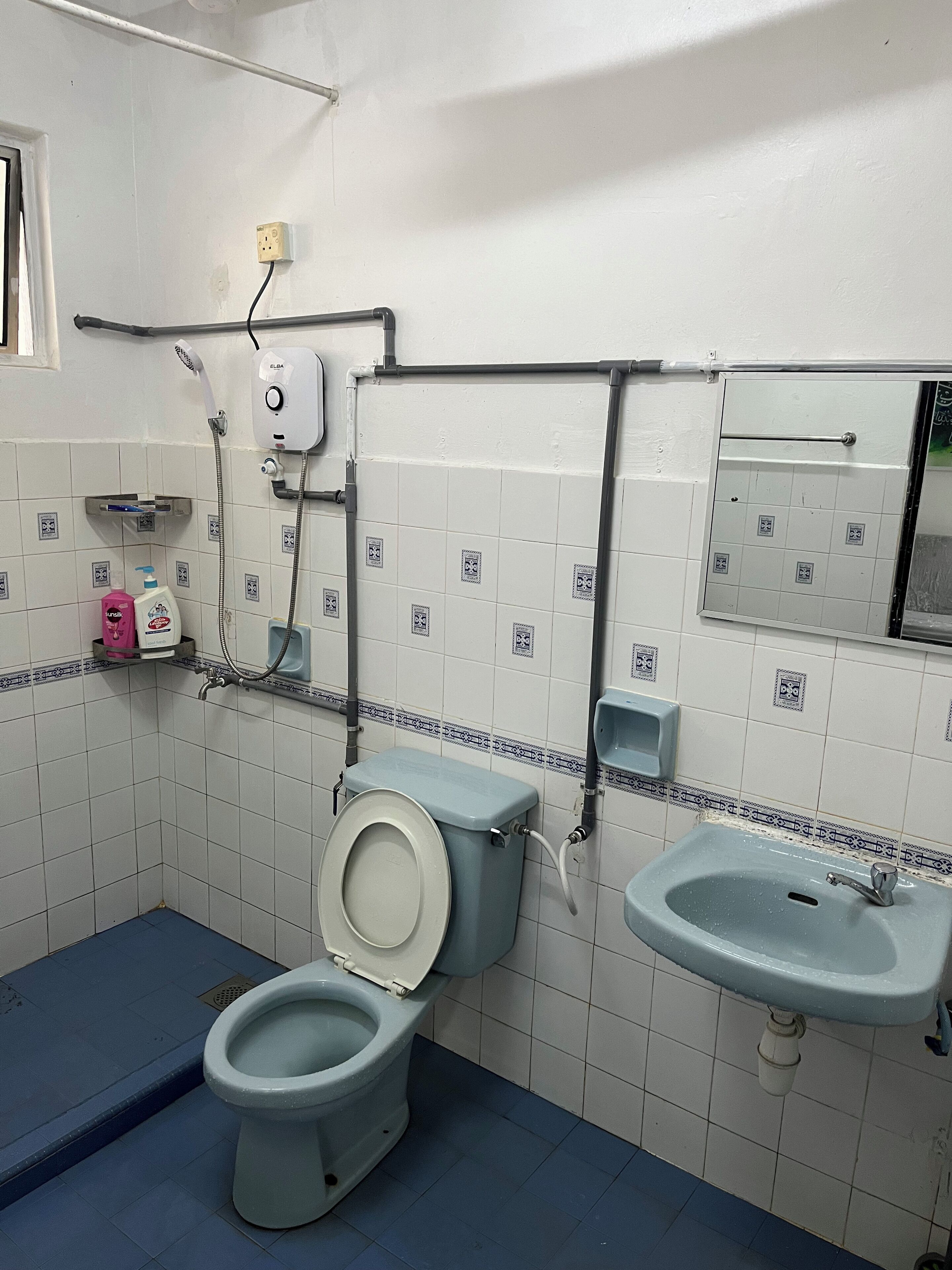 A bathroom with a toilet, sink, and shower.
