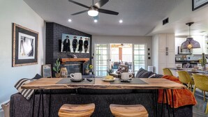 Una cucina moderna con isola centrale, sgabelli da bar e ventilatore a soffitto.
