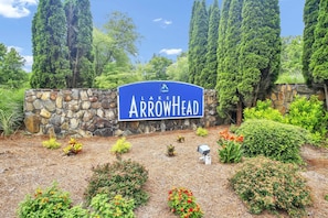 A sign for Lake Arrowhead with a stone wall and landscaped garden. - 2BR+Loft |Screened Patio| Lake Views at Arrowhead |Pool, Tennis, Boating, Hiking, Dining, Pickleball (Waleska)