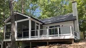 A two-story house with a covered porch and a chimney.