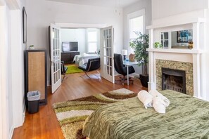 Een moderne slaapkamer met een bed, een bureau en een open haard.