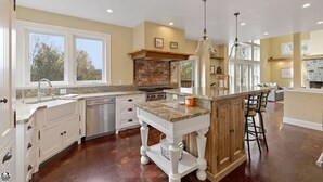 A spacious kitchen with a large island, built-in appliances, and ample natural light from large windows.