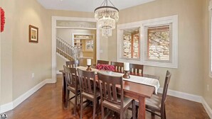 A dining area with a chandelier, wooden table, and chairs.