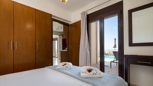 Une chambre d’hôtel avec un grand lit, une armoire en bois et une vue sur une piscine.